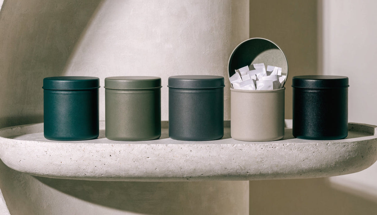 Row of caffeine pouch tins lined up on a shelf, one open