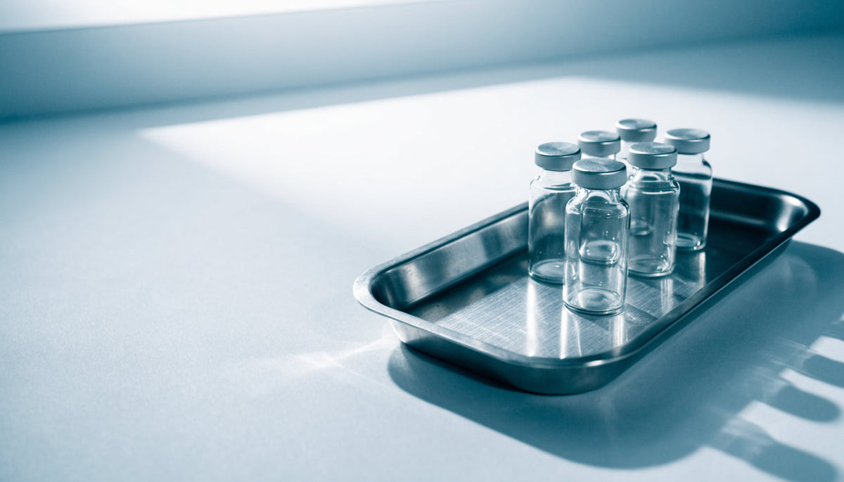 Steel tray of small unlabeled vials in a bright modern clinic