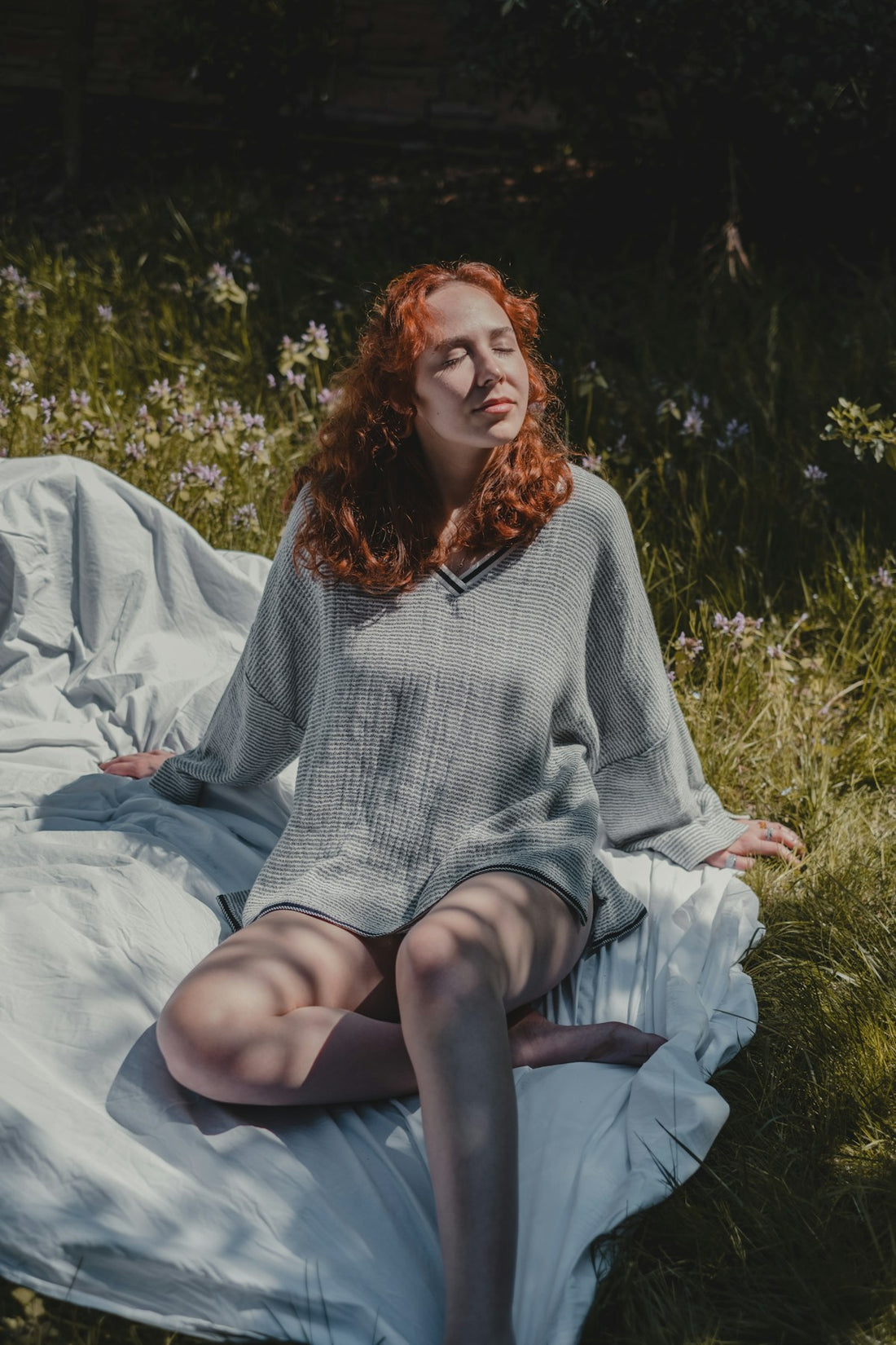 Calm woman in gray sweater sitting relaxed