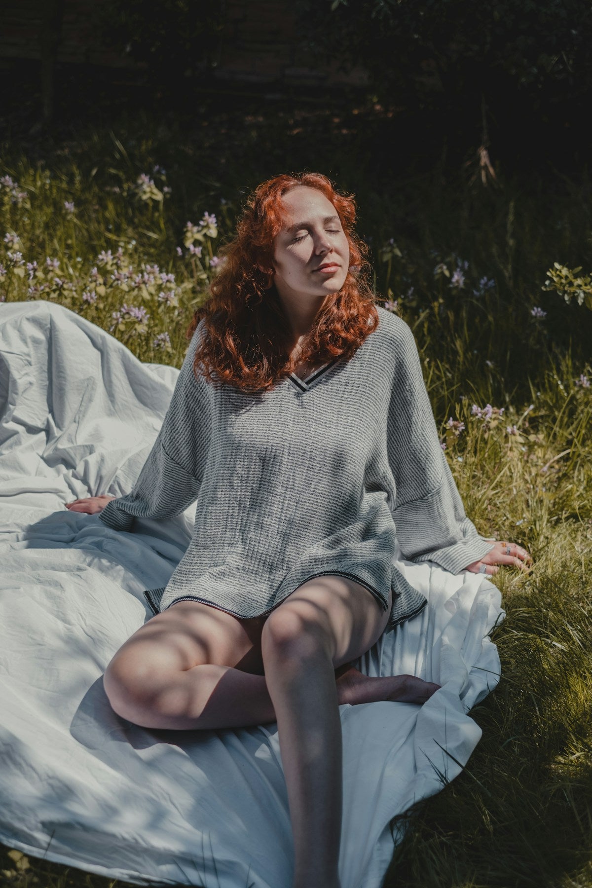 Calm woman in gray sweater sitting relaxed
