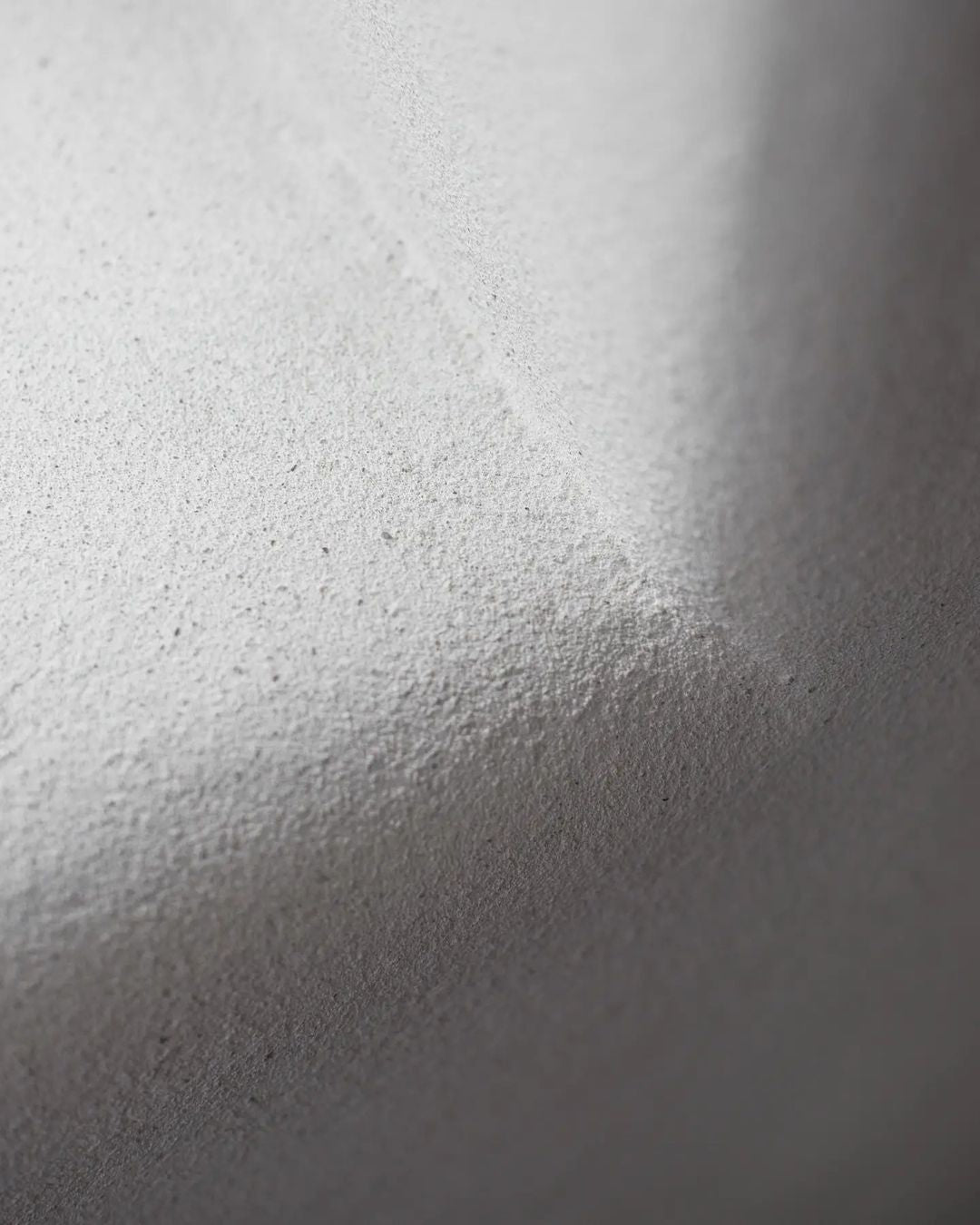 Close-up of a textured white surface with light and shadow